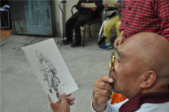 老人在认真看画像 蒋正摄